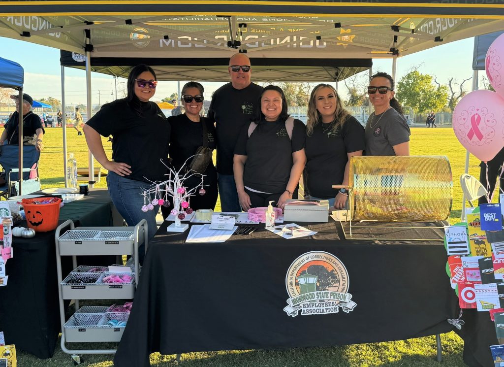Staff from ISP standing at cancer awareness booth