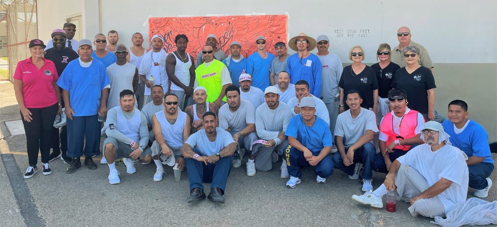 Incarcerated people and a banner for cancer awareness.