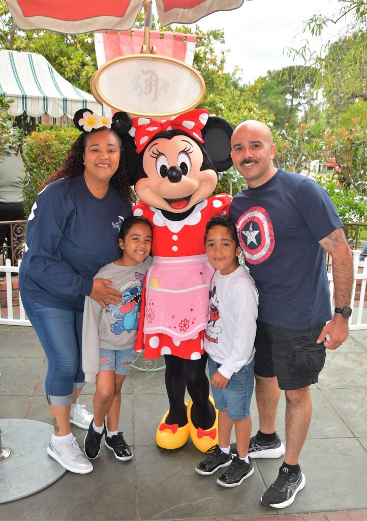 Melendrez with his wife and two children pose for a photo with Minnie Mouse.