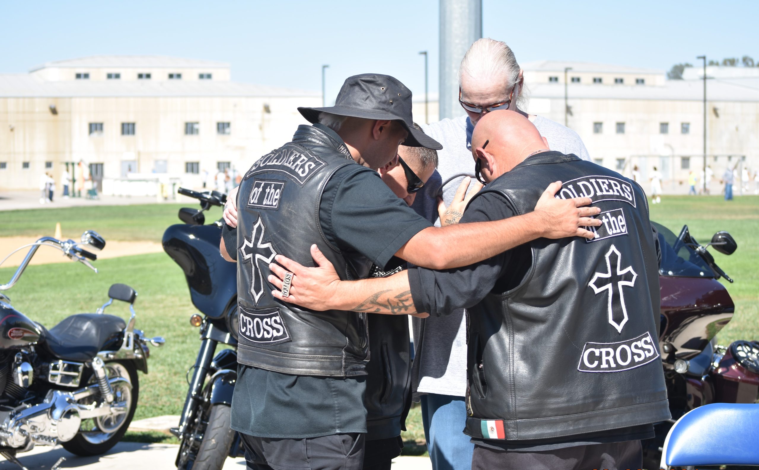 Mule Creek religious volunteers bow their heads and pray with an incarcerated person at Mule Creek State Prison during the seminary program kick-off event.