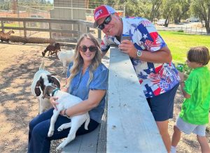 A petting zoo with a woman holding a goat.