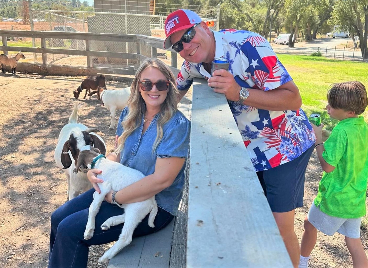 A petting zoo with a woman holding a goat.