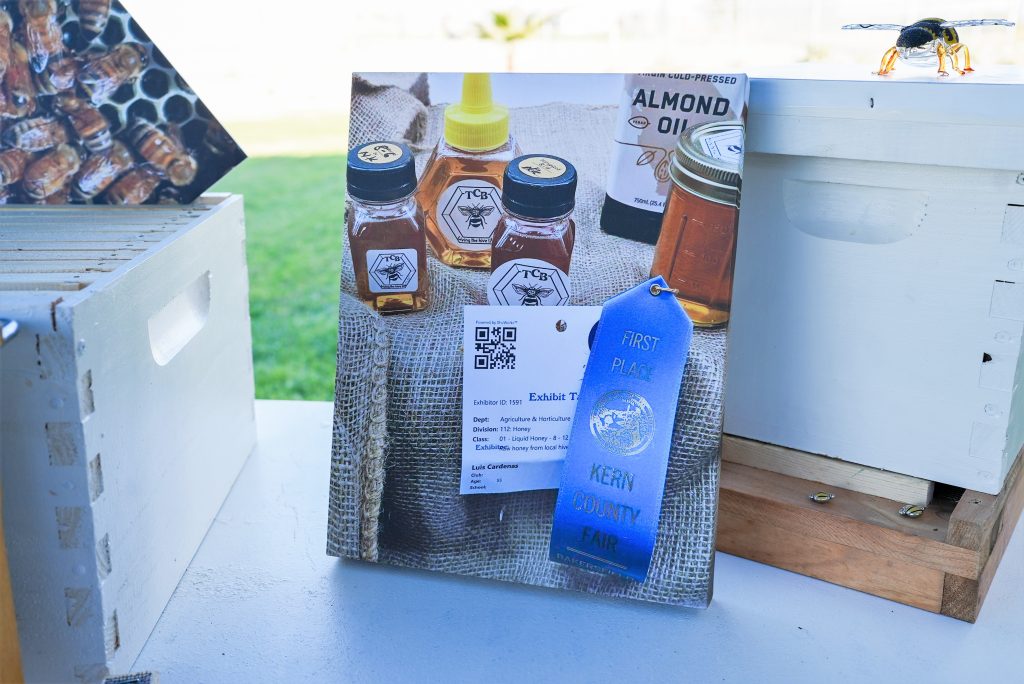 Photo of honey with a blue ribbon.