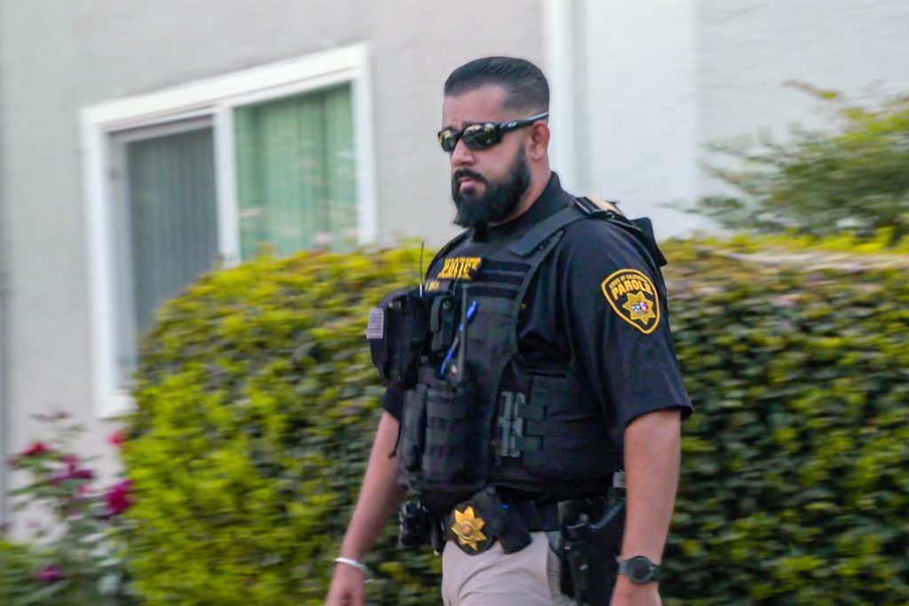 A parole agent walks in a neighborhood during Halloween night for Operation Boo.