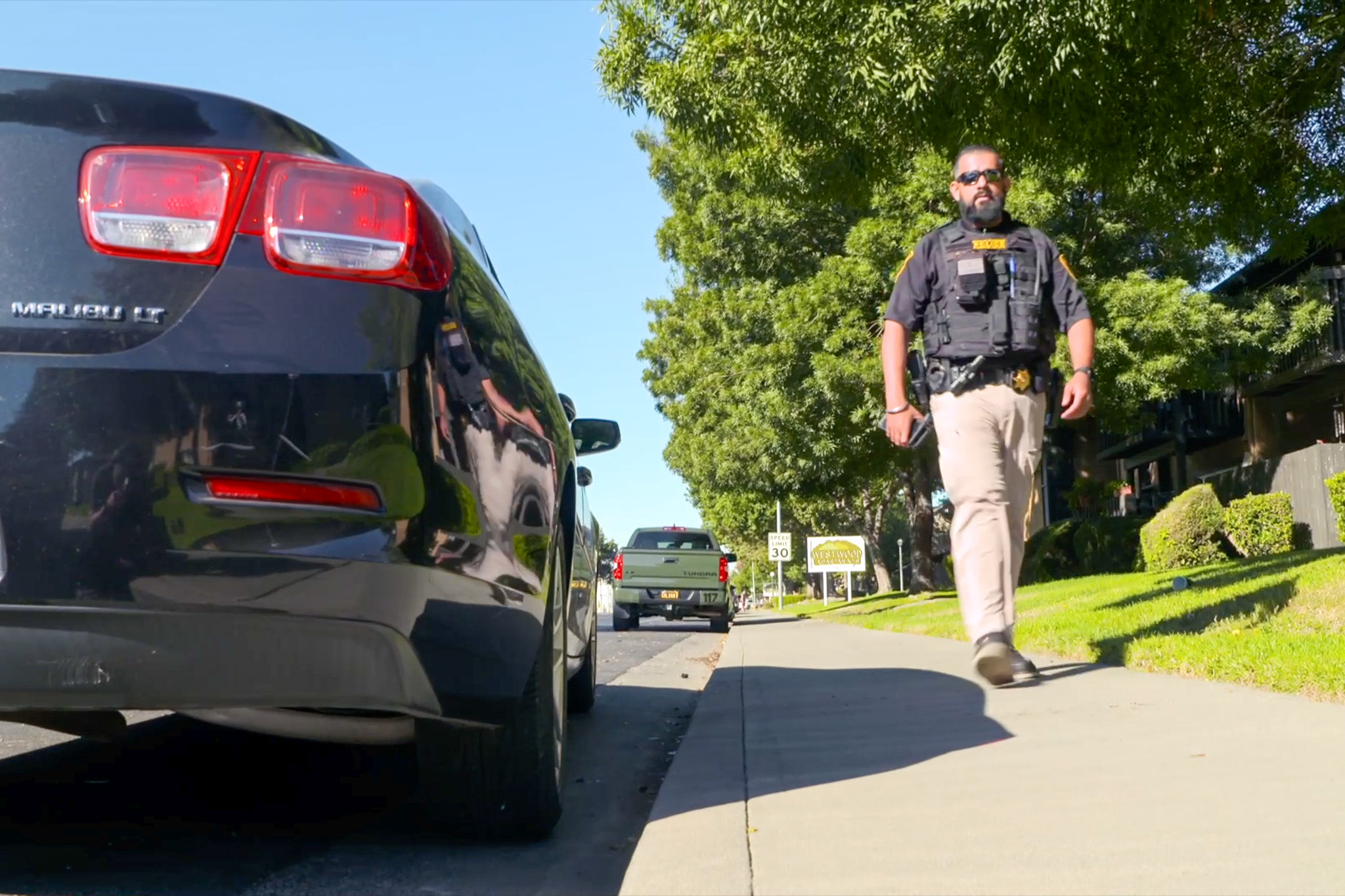 Parole Agent Singh walks on a sidewalk.
