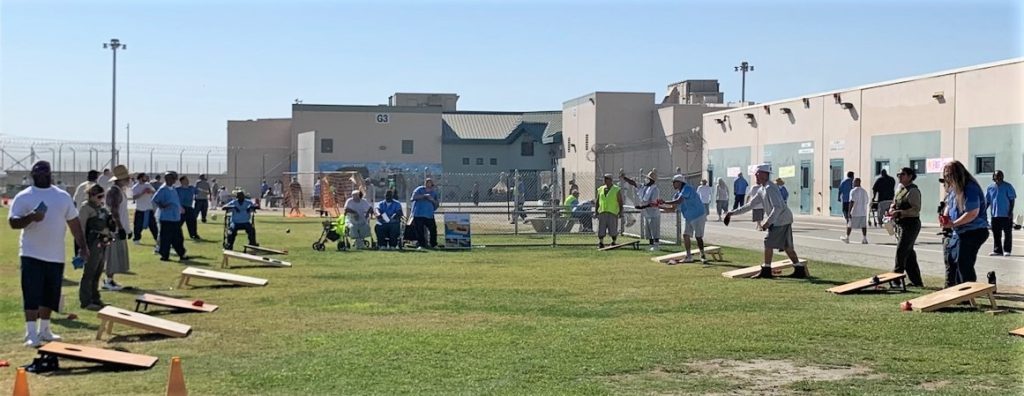 Staff and population play corn hole at SATF for Day of Abilities event.