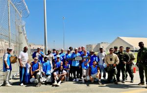 SATF softball game with incarcerated players and staff posing for a group photo.