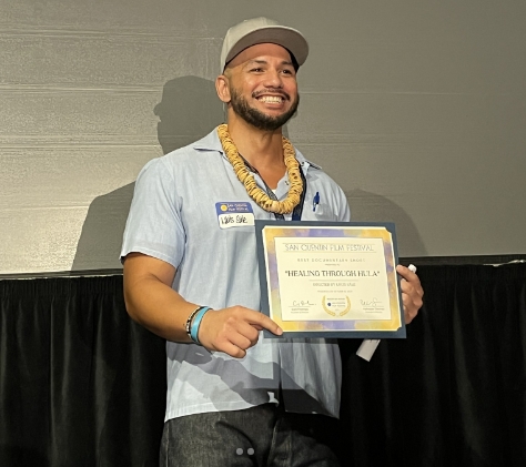 Filmmaker Louis Sale at the San Quentin Film Festival with his award for Best Documentary Short.