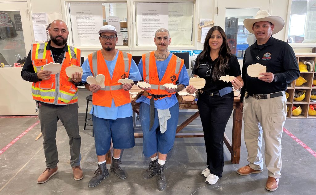 Incarcerated students at Calipatria hold Halloween decorations they created.