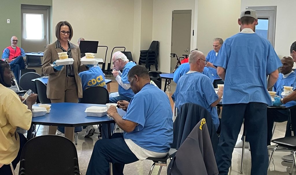 Veterans banquet at CHCF with the warden serving cake.