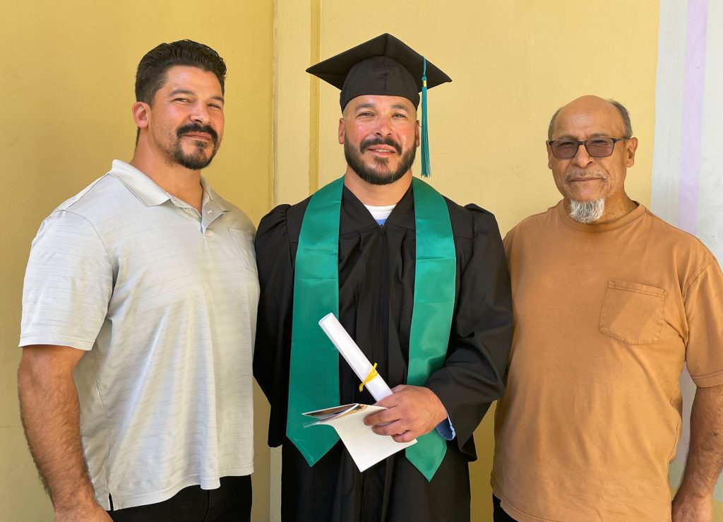 A graduate stands with his family at CMC.