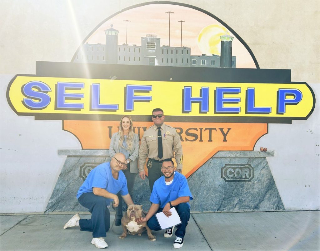 Incarcerated trainers with Tyson, who recently graduated training with four other dogs, at Corcoran prison.