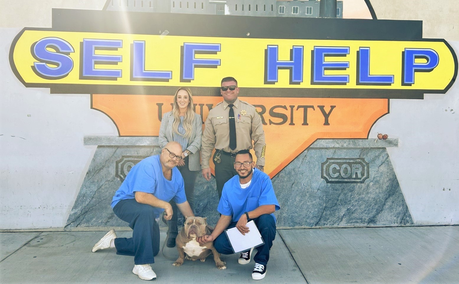 Incarcerated trainers with Tyson, who recently graduated training with four other dogs, at Corcoran prison.