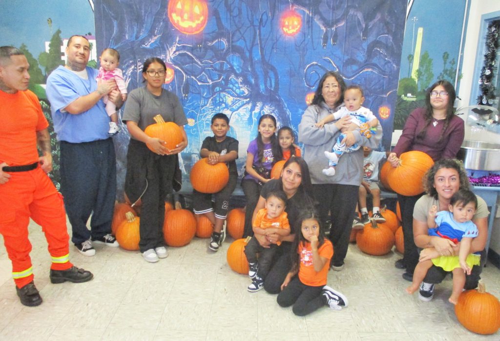 Visiting families at California Rehabilitation Center with their incarcerated loved ones and a Halloween-themed visiting room.