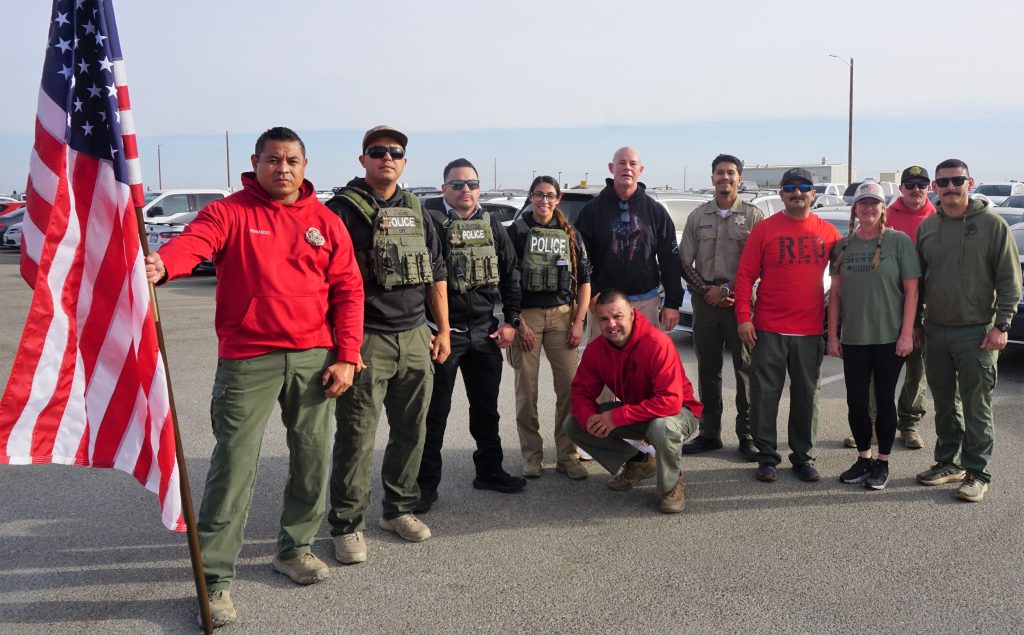 Kern Valley State Prison's Veterans Day Walk and Run group photo with one person holding an American flag.