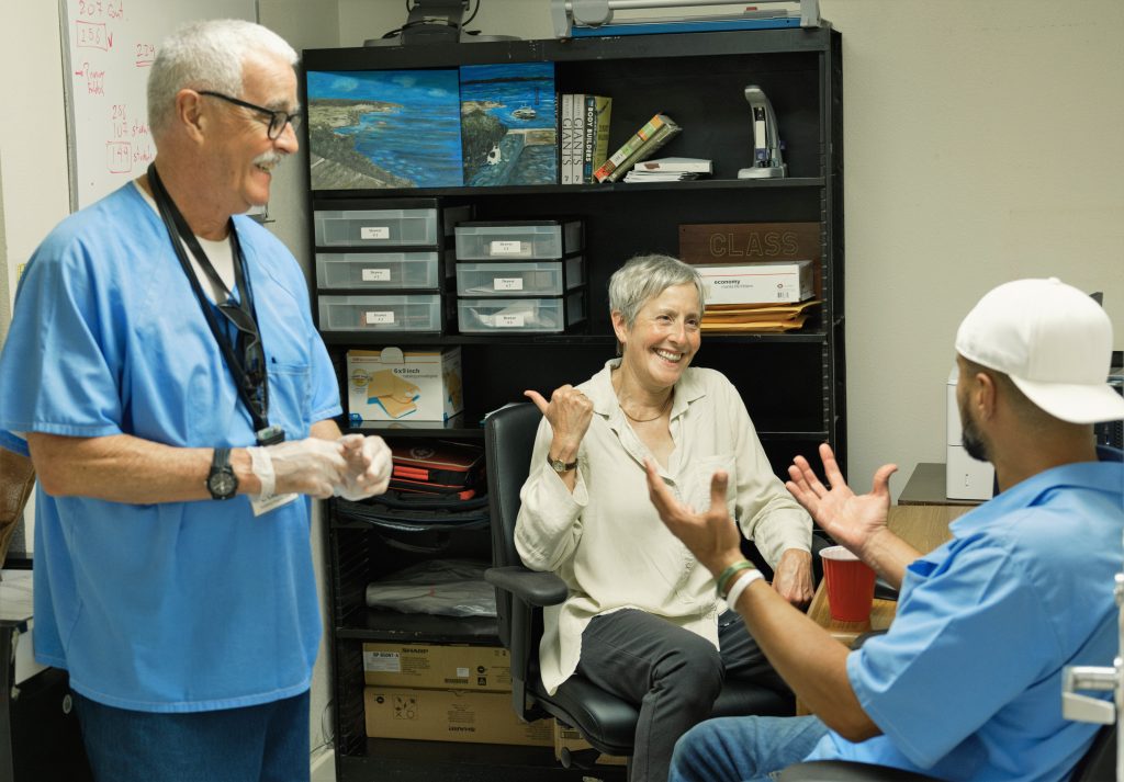 Prison college founder with two incarcerated people at San Quentin.