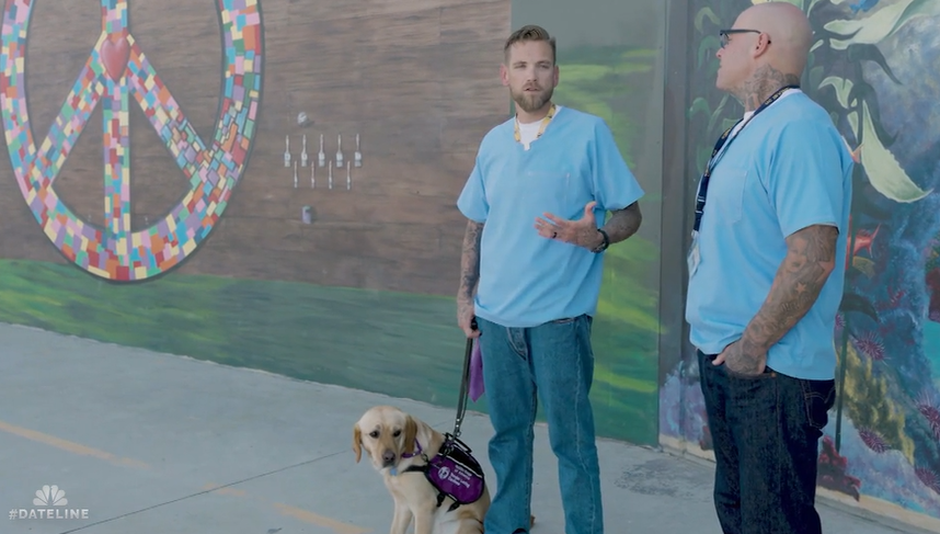 two men standing with a dog