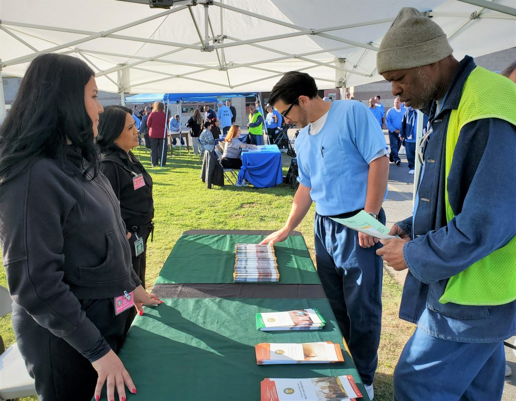 victim services staff at booth speaking with incarcerated