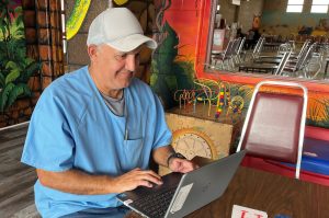 An incarcerated student types on a laptop.