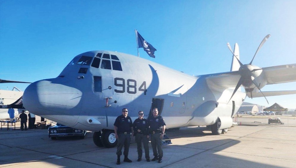 Recruiters stand in front of a large plane.