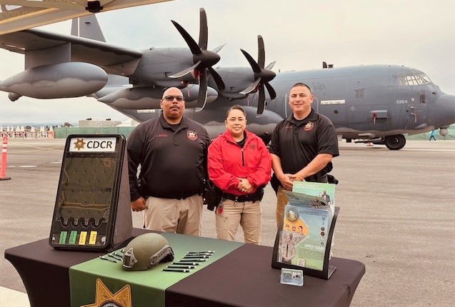 CDCR recruiters with a plane behind them at an airshow in Salinas.