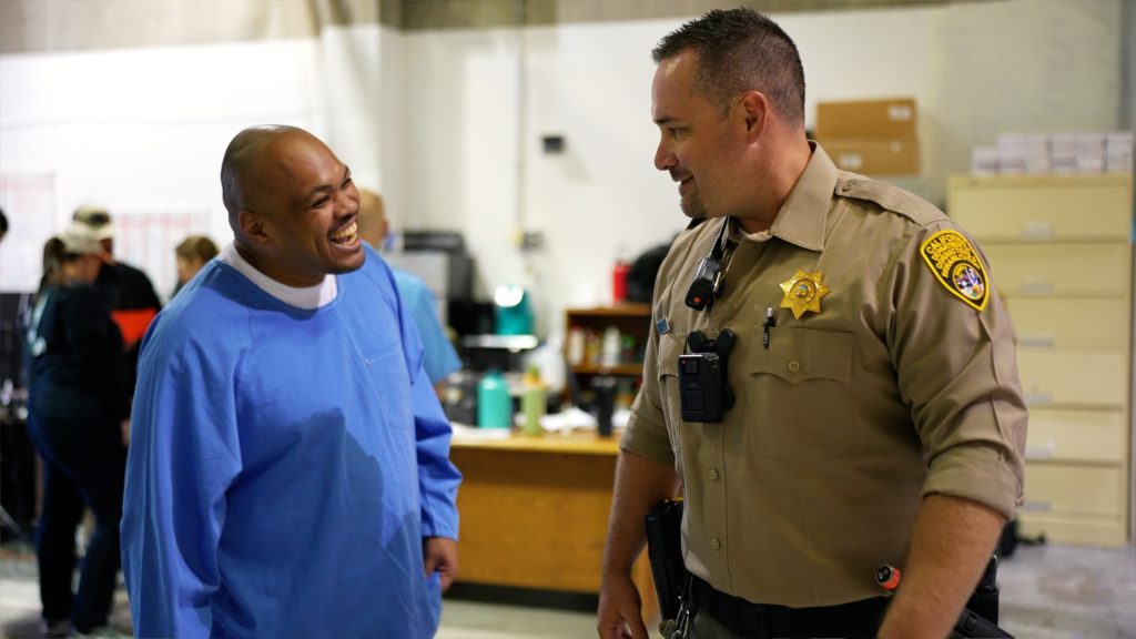 Incarcerated person and officer talk during Sac360 events in the prison, part of a rehabilitation program.