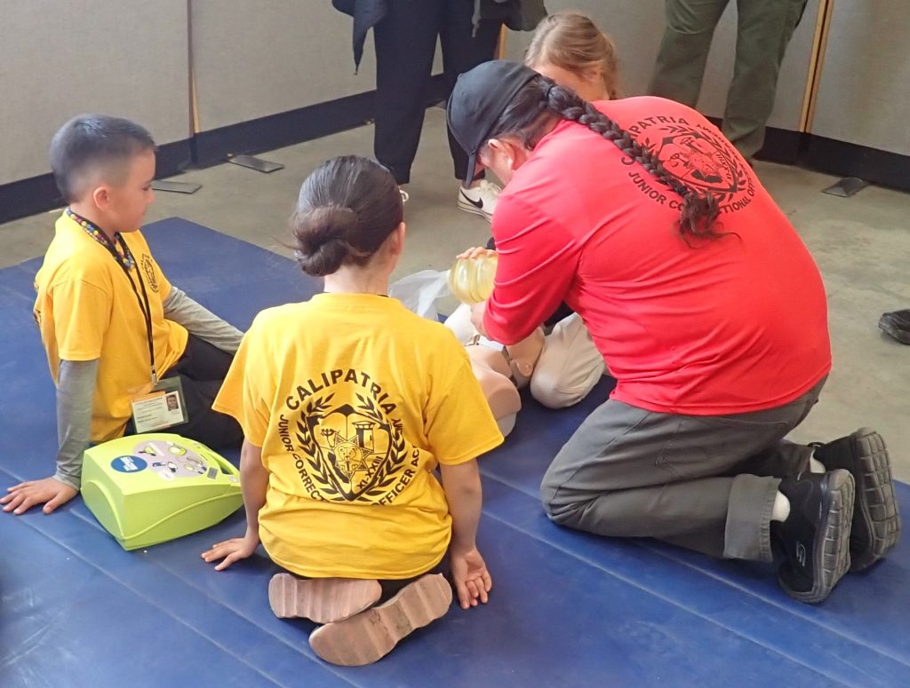 An adult demonstrates cardiopulmonary resuscitation at the academy.