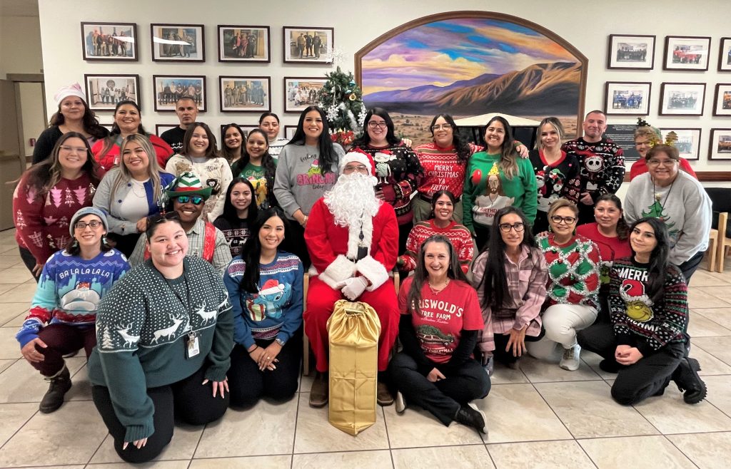 Staff wearing Christmas sweaters and one person wearing a Santa suit at Calipatria State Prison. 