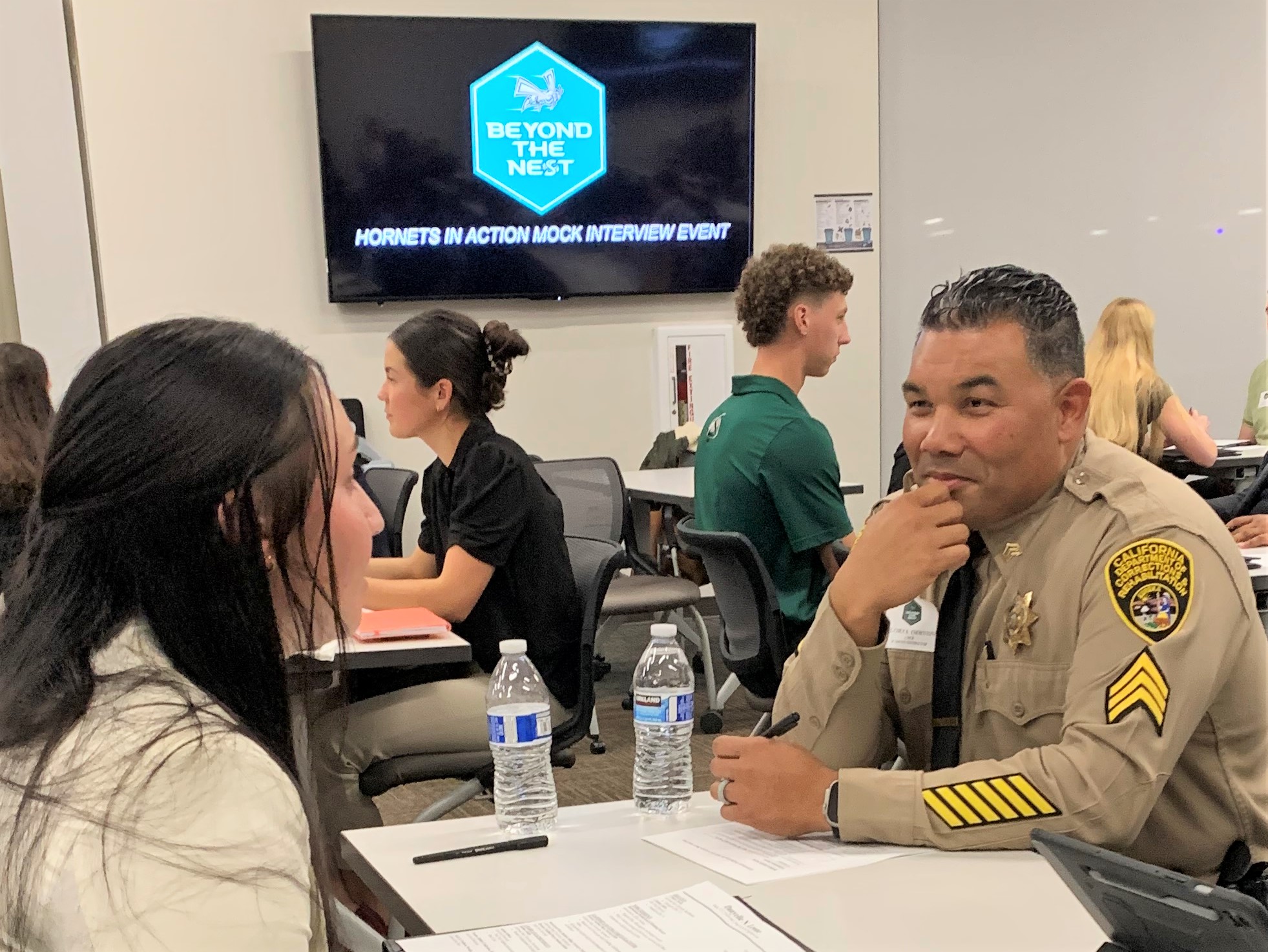 A CDCR recruiter speaks with a student athlete at Sac State University.