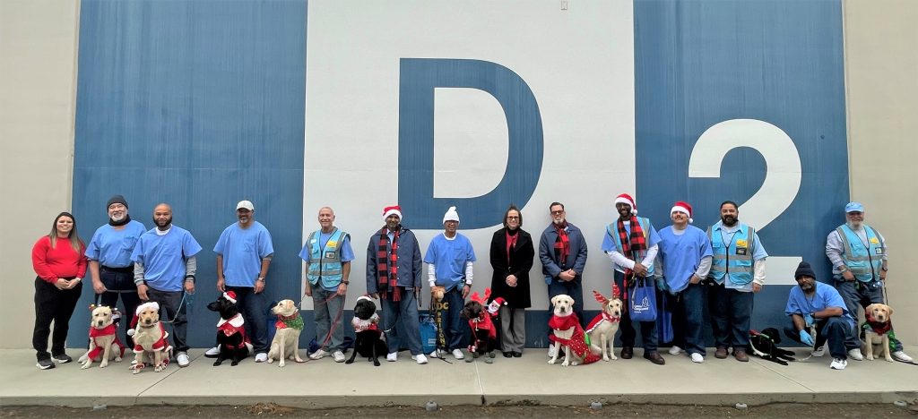 The puppy parade participants with dogs wearing holiday costumes at CHCF.