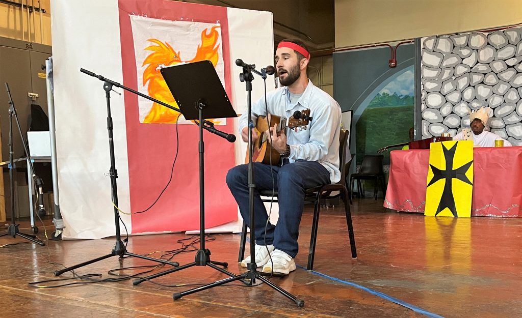 A man sings and plays guitar at a holiday talent show at California Men's Colony in San Luis Obispo.