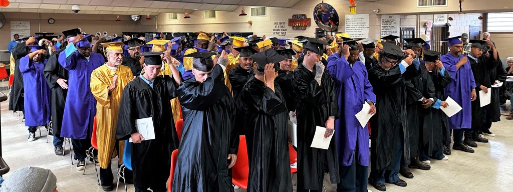 A group photo of student graduates wearing caps and gowns.