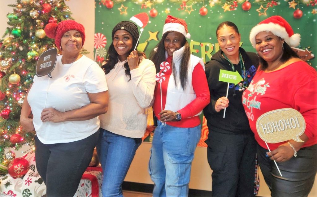 Los Angeles Central District parole toy drive with five people posing beside a Christmas tree.