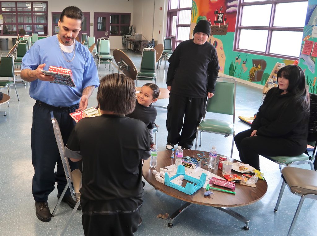 A family at High Desert State Prison opens gifts on Christmas Day.
