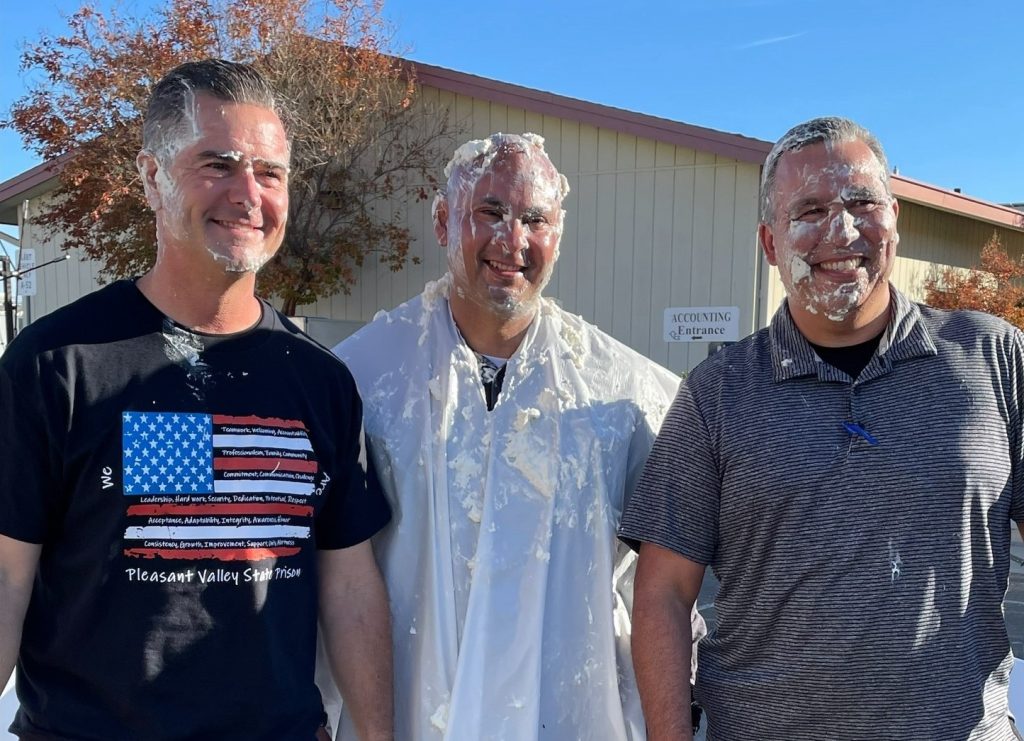 Three people with whipped cream on their faces at Pleasant Valley State Prison.
