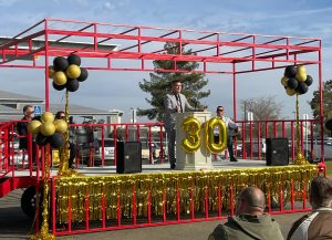 Pleasant Valley prison warden speaks while standing on a stage.