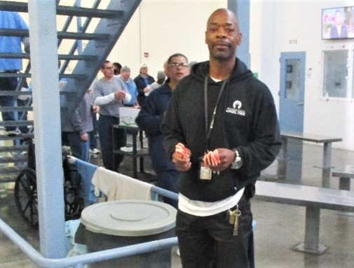 A pastor holds candy canes to distribute on Facility E at RJ Donovan Correctional Facility.