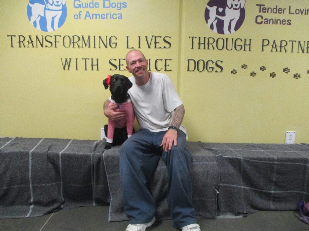 An incarcerated person and his dog at RJ Donovan Correctional Facility on E yard.
