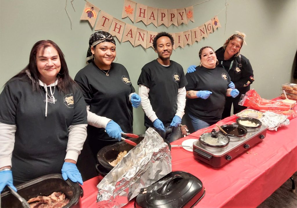 Volunteers serve Thanksgiving meal at a parole meeting.