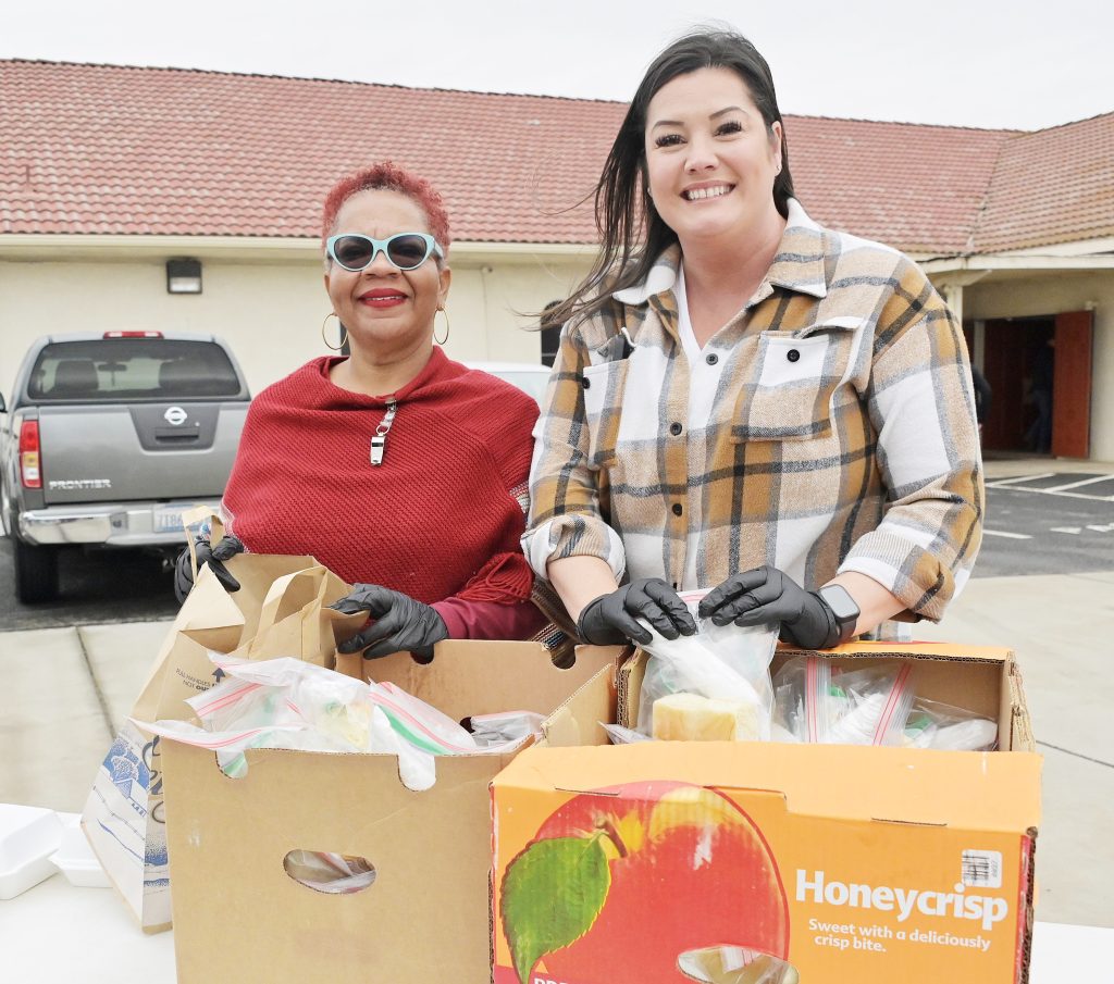 Two people with boxes open to distribute food in Fairmead.