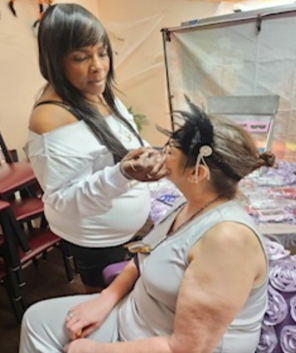 make-up artist working on seated individual