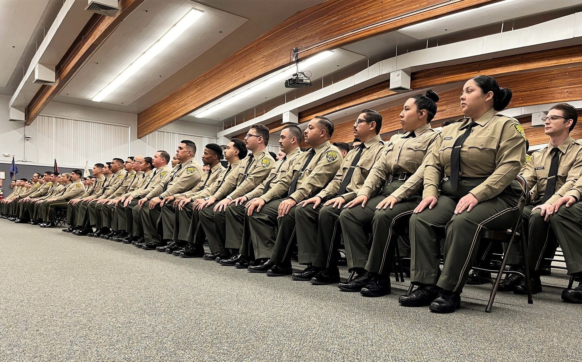 Basic Correctional Officer Academy cadets sit at the graduation ceremony in Galt.