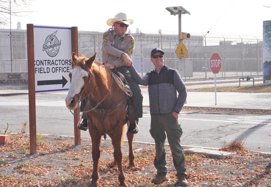 Shaking hands with another person while on horseback.
