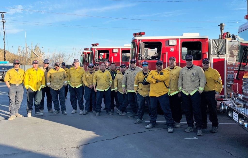 Strike team members stand beside fire engines sent from CDCR institution fire houses.