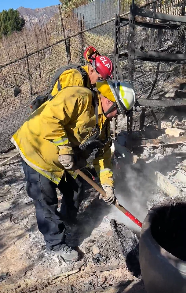 Two members of the CDCR strike put are shown putting out hotspots in the aftermath of the Palisades fire in Southern California.