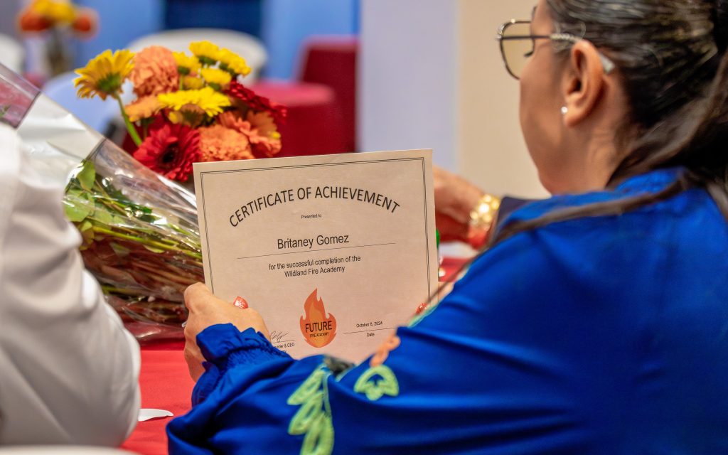 Britaney Gomez holds her certificate of achievement after graduating the fire academy.