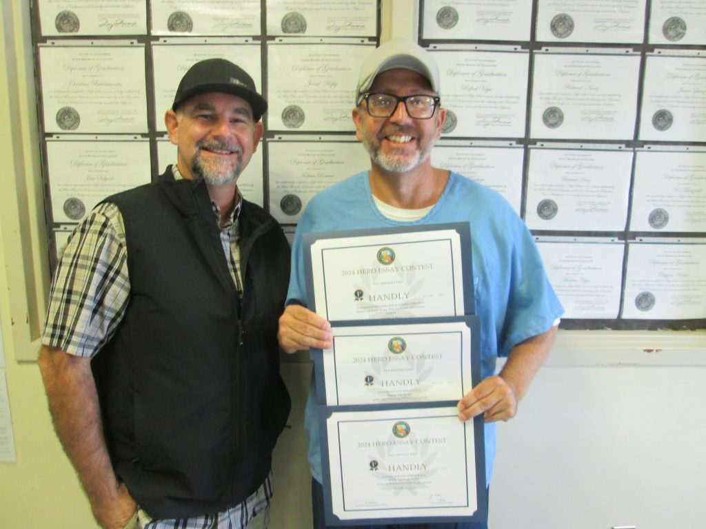 Educator with an OCE essay contest winner at Avenal State Prison.