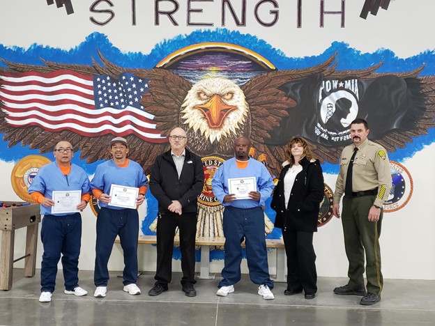 Staff with OCE essay writing contest winners at High Desert State Prison.