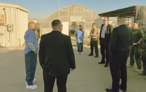 With a greenhouse in the background, Secretary Macomber visits staff and incarcerated at SATF in Corcoran.