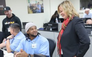 A woman speaks with a student enrolled in The Last Mile computing coding CALPIA program at San Quentin Rehabilitation Center.